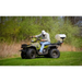 Operator on green ATV with white Swisher ATV Commercial Pro Spreader attached at rear on grass, gallery position 1