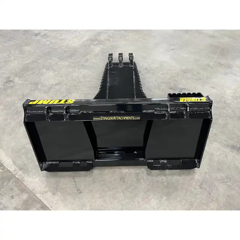 Black steel skid steer stump bucket attachment with reinforced cutting edge on concrete floor indoors