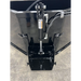 Black steel skid steer concrete bucket with central hydraulic cylinder and welded mounting brackets on concrete floor