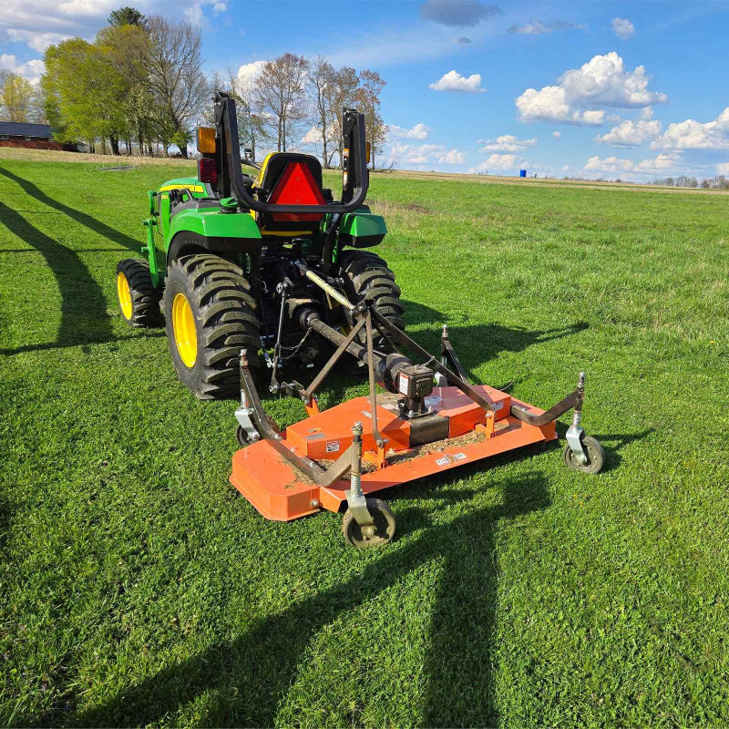 rear angled view of orange 60-inch MechMaxx PTO finishing mower attached to green tractor, gallery position 1