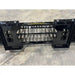 Black skid steer attachment with narrow spaced tines and reinforced mounting frame on concrete floor