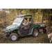 Green utility vehicle towing Swisher 16 cu ft poly cart with gear in wooded area, gallery position 1