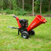 Red MechMaxx GS650 7hp gas wood chipper with towbar and large pneumatic tires on grass outdoors, gallery position 1 view