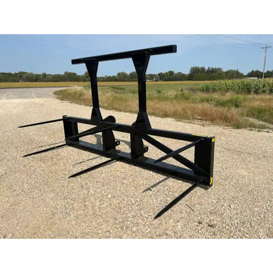 Black steel skid steer attachment with five pointed tines and reinforced frame on gravel road near grassy field