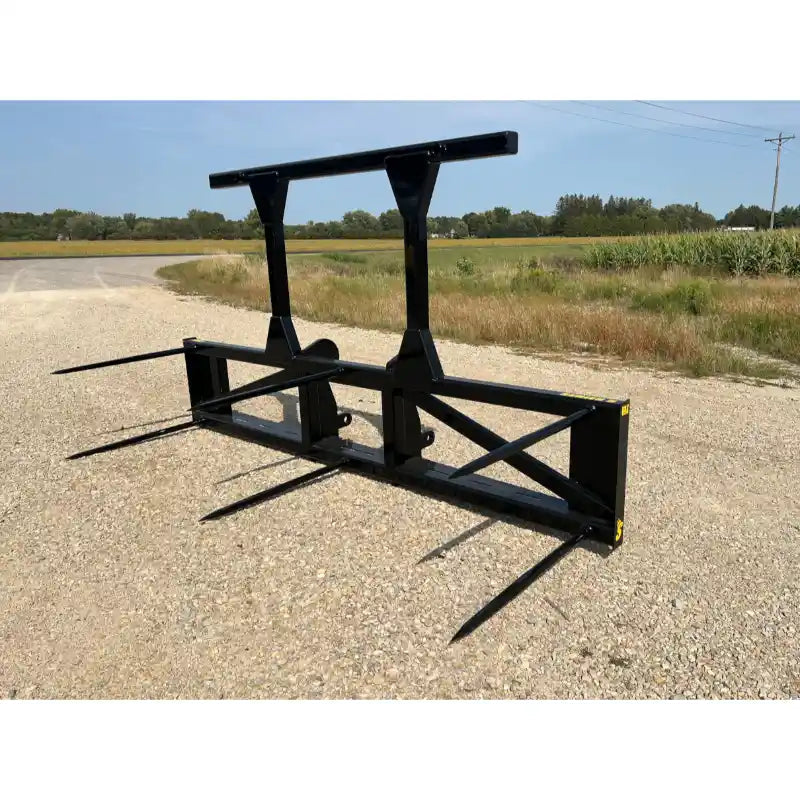 Black steel skid steer attachment with five pointed tines and reinforced frame on gravel road near grassy field
