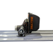 Side profile of black mechanical concrete bull float vibrator attachment mounted on aluminum screed rail