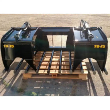 Wide black metal skid steer grapple attachment with dual hydraulic cylinders and spaced curved tines on pallet outdoors