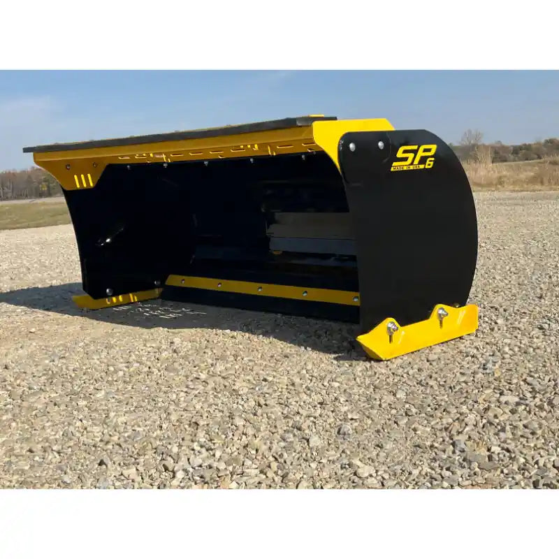 Front-left angle of black and yellow skid steer snow pusher attachment with bolted cutting edge on gravel surface