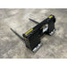 Black steel bale spear skid steer attachment with two long pointed tines on concrete floor