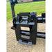 Black painted steel quick-attach skid steer adapter plate with locking mechanism on gravel surface