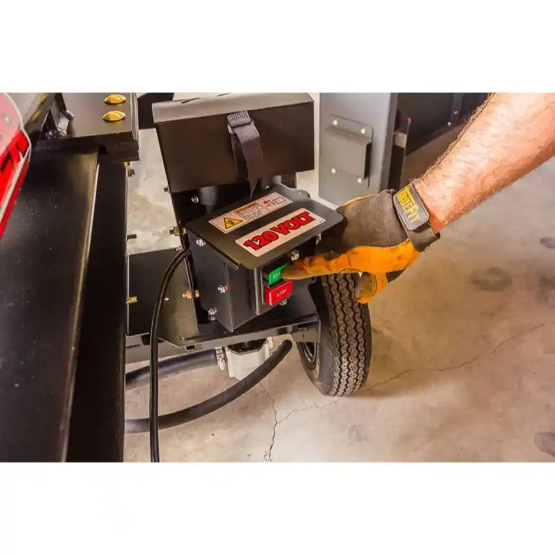 Close-up of operator's gloved hand pressing control switch on Swisher 22-Ton Timber Brute Eco Split electric log splitter, gallery position 1