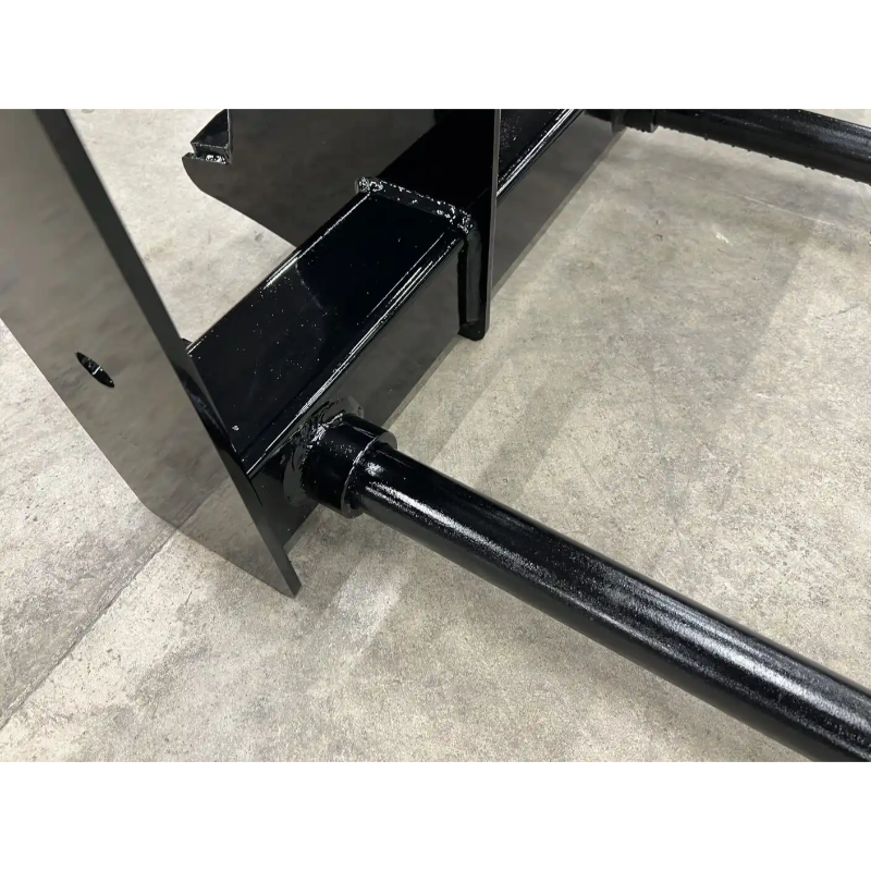 Close-up of black metal frame with welded joints on concrete floor, showing structural components of equipment attachment.