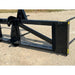 Black steel loader attachment with reinforced welded frame and tapered spears on gravel surface outdoors