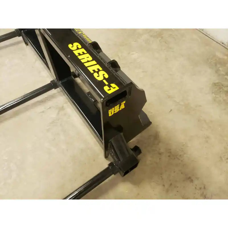Close-up of Stinger Attachments BS3 Series 3 Skid Steer Bale Spear showing black metal frame with yellow lettering, gallery 10, 800x800px.