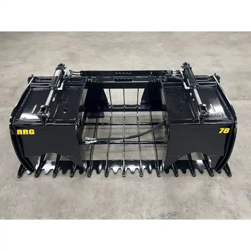 Black steel tractor grapple attachment with hydraulic cylinders, solid tines, and grid-style center on concrete floor
