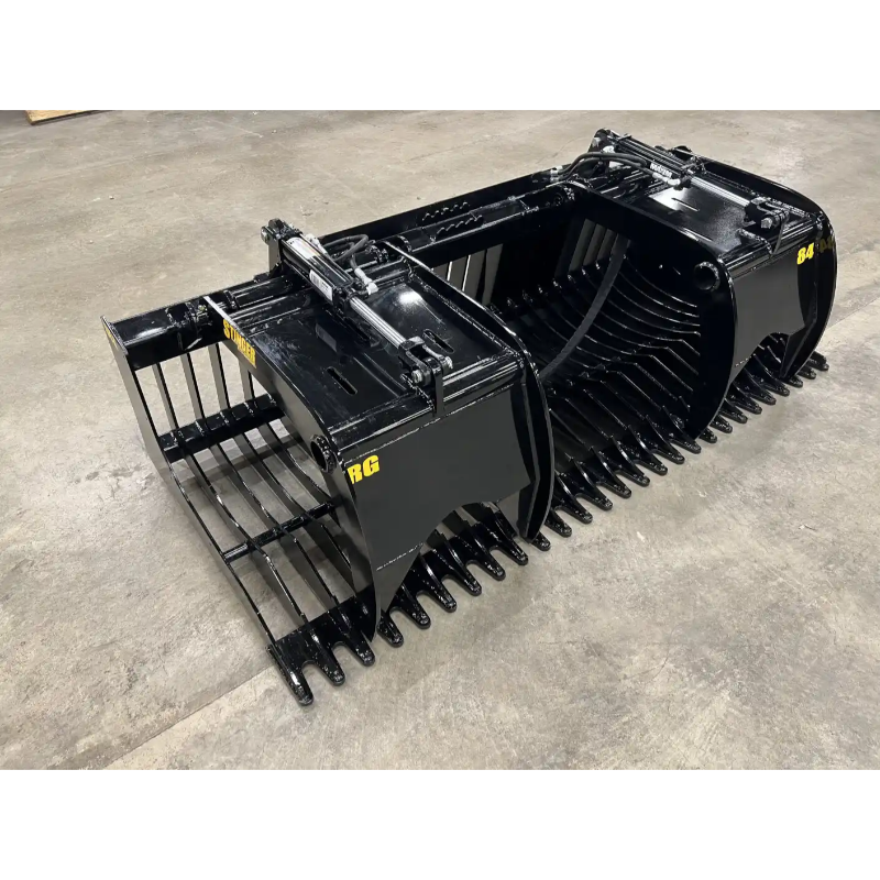 Black steel rock grapple attachment with twin hydraulic cylinders and wide curved tines on concrete floor