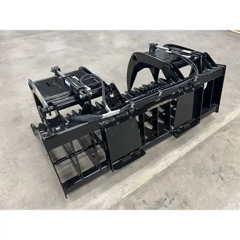 Black steel tractor grapple attachment with hydraulic cylinders, spaced tines, and solid side panels on concrete floor