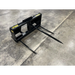 Black skid steer bale spear attachment with three long pointed spears on concrete floor