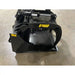 Black skid steer grapple bucket attachment with hydraulic cylinder and clamp arm on concrete floor indoors