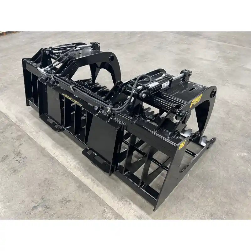 Black steel tractor root and rock grapple attachment with dual hydraulic cylinders and reinforced frame on concrete floor