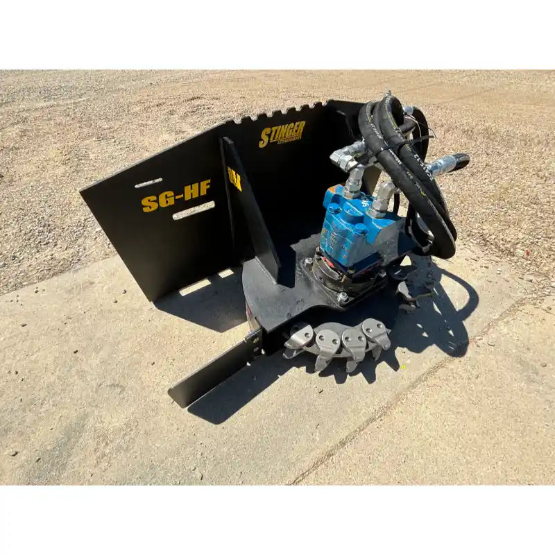 Hydraulic stump grinder attachment with rotating cutting wheel, steel guard, and multiple hydraulic hoses on dirt surface