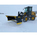 Yellow and black skid steer loader equipped with a large steel snow pusher blade clearing fresh snow