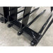Close-up view of black metal grapple tines with bolts and reinforced welds on concrete floor indoors