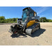 John Deere compact track loader with skid steer stump grinder attachment and hydraulic hoses on gravel surface