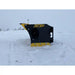 Side profile of a black and yellow skid steer snow pusher attachment positioned on snow-covered ground outdoors