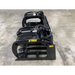 Black painted skid steer grapple attachment with curved tines, hydraulic hoses, and reinforced frame on concrete floor