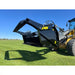 Side view of black tractor rock bucket attachment mounted on yellow and black loader on green grass under clear sky