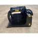 Black skid steer rock grapple attachment with spaced curved tines, hydraulic cylinders, and hoses on dirt surface outdoors