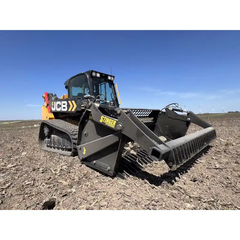 Front-left angled view of black skid steer with rock reel attachment on dry soil under clear blue sky